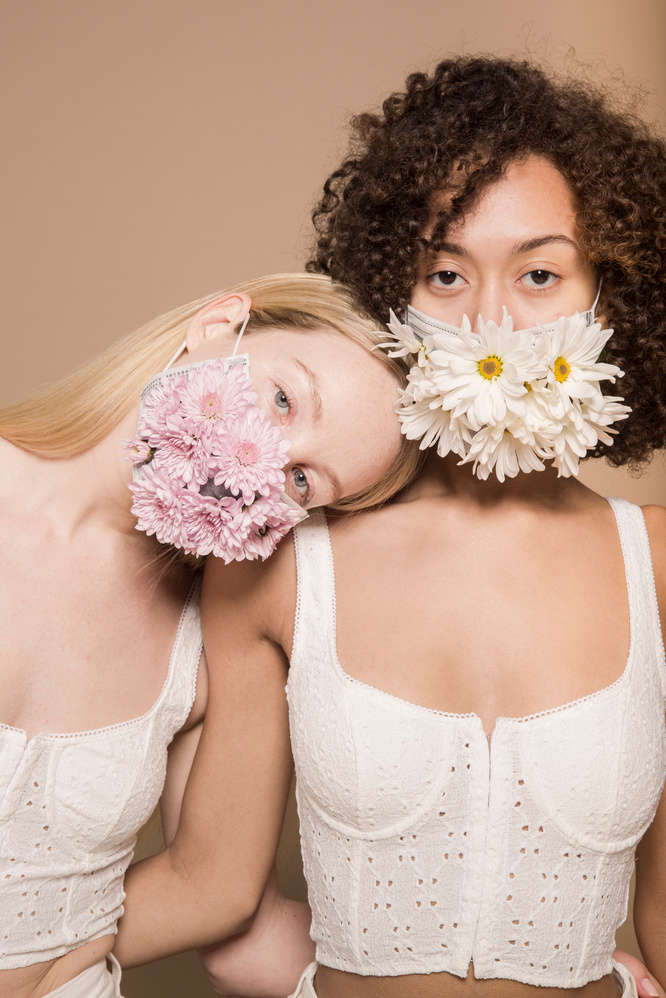 Multiracial women wearing colorful flower masks